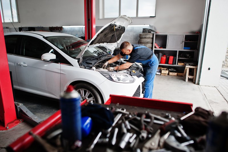 Car Repair And Maintenance Theme. Mechanic In Uniform Working In